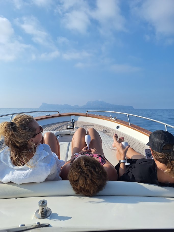 Guests relaxing on the deck of a private boat during a transfer from Naples to Capri