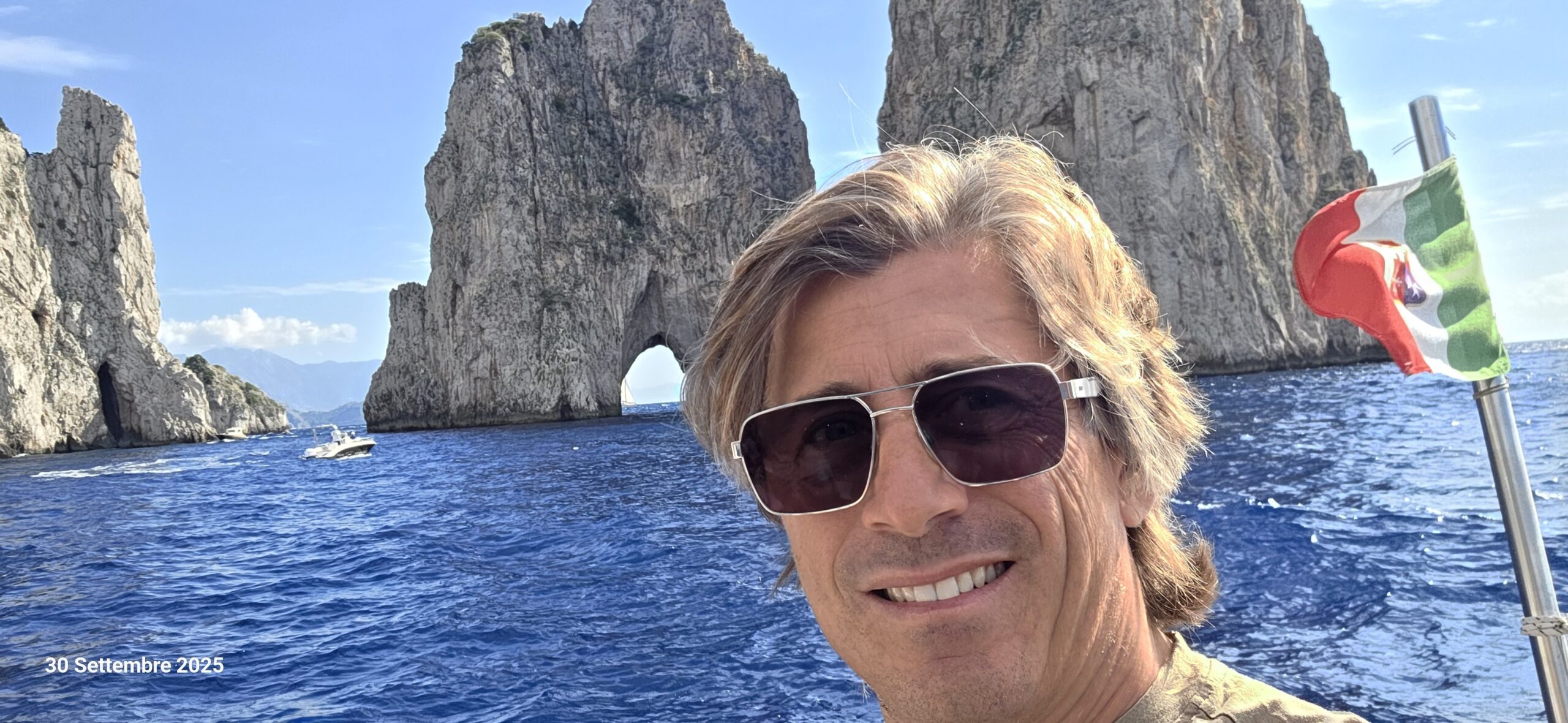 Boat captain in front of the Faraglioni rocks during a private transfer to Capri