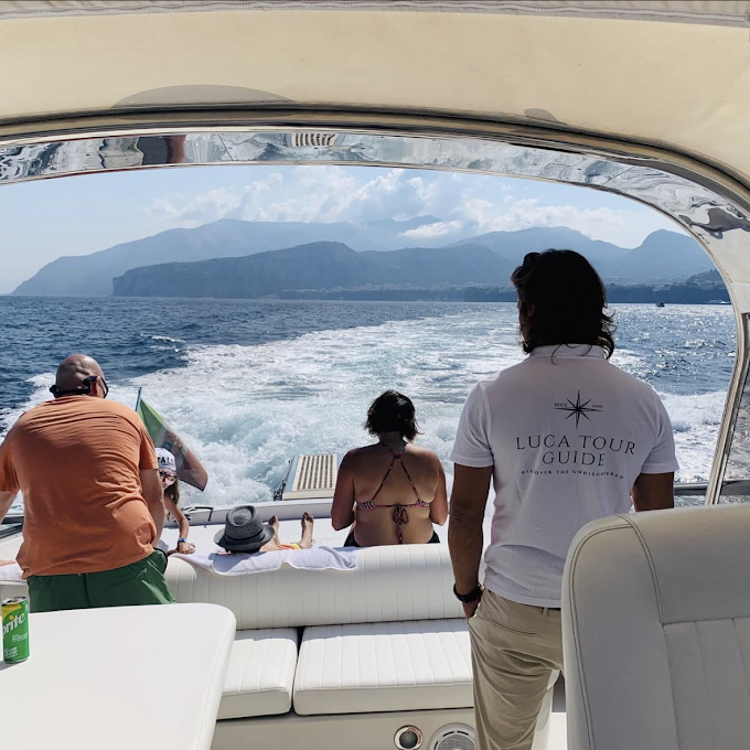 Guests relaxing on the deck of a private boat during a transfer from Naples to Capri