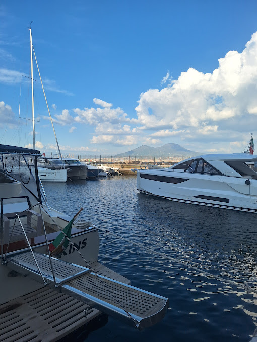 Private boat captain at Naples port, with a cruise ship in the background — transfer coordination service